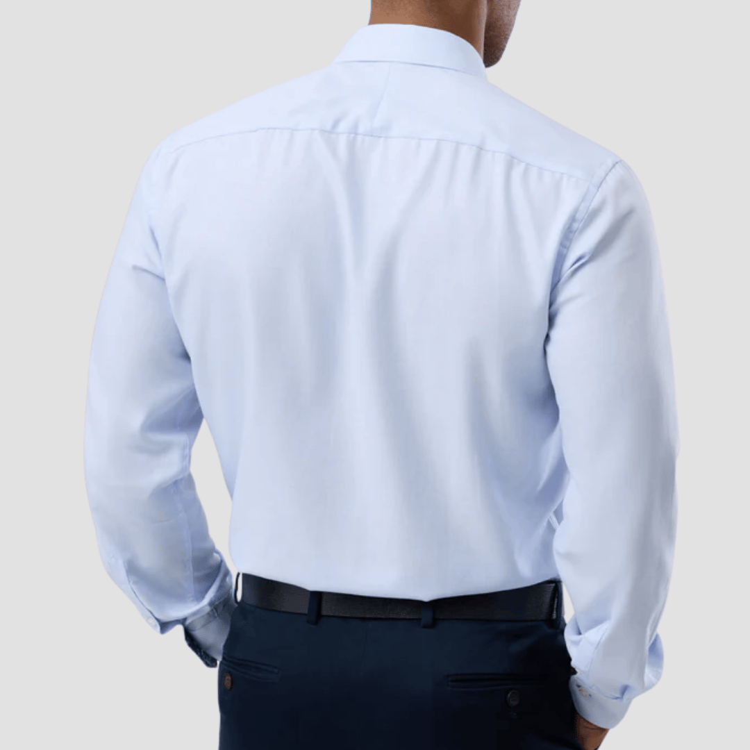 Person wearing a light blue dress shirt and dark pants