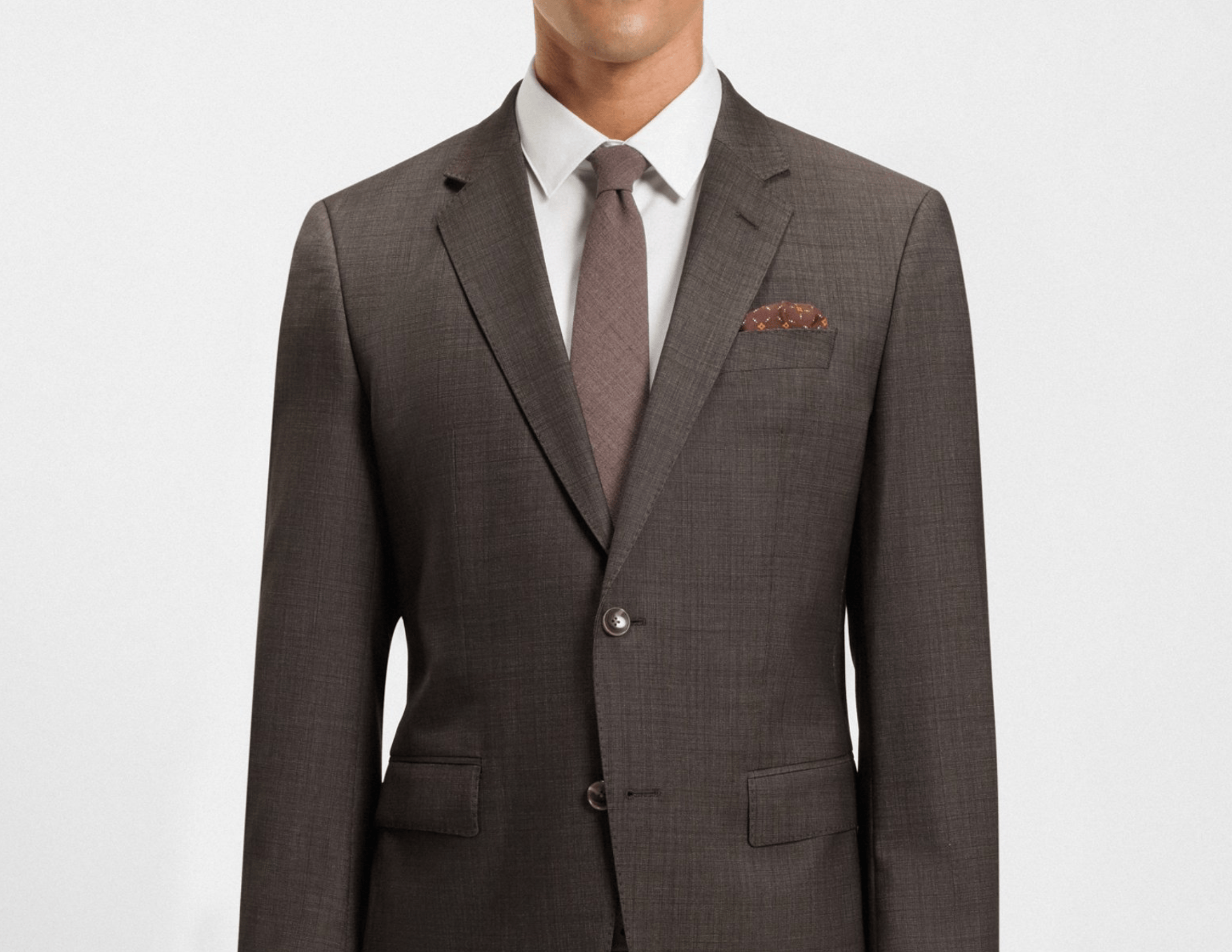 Gray suit with a white shirt, gray tie, and brown pocket square on a light gray background