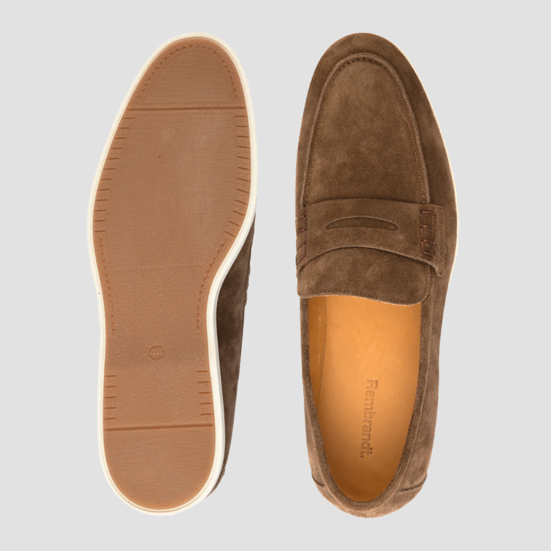 Brown suede loafer shoe with sole on a light gray background
