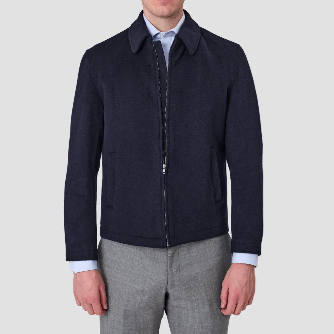Man wearing a navy wool zip up jacket by Savile Row over a light blue shirt and gray pants.