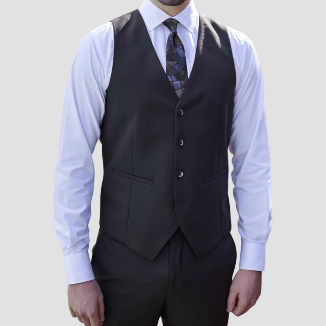 Man wearing a dark brown-black vest by Savile Row over a light blue shirt with a patterned tie.