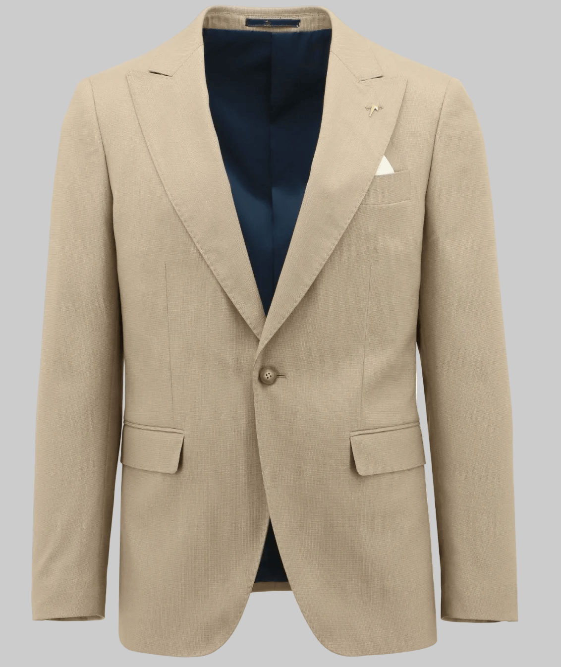 A beige single-breasted suit jacket with a single gold button, displayed on a white background with a navy blue shirt and white pocket square visible underneath.