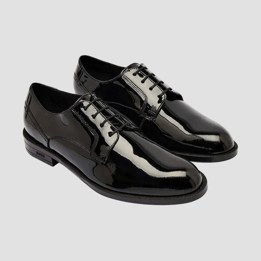 Pair of black patent leather shoes on a white background