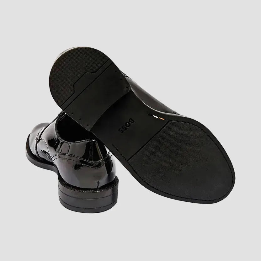 Black patent leather shoes on a white background