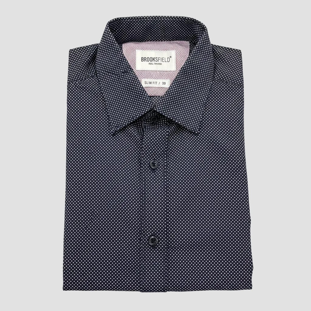 Black patterned shirt with Brooksfield label held by a hand on a reflective surface.