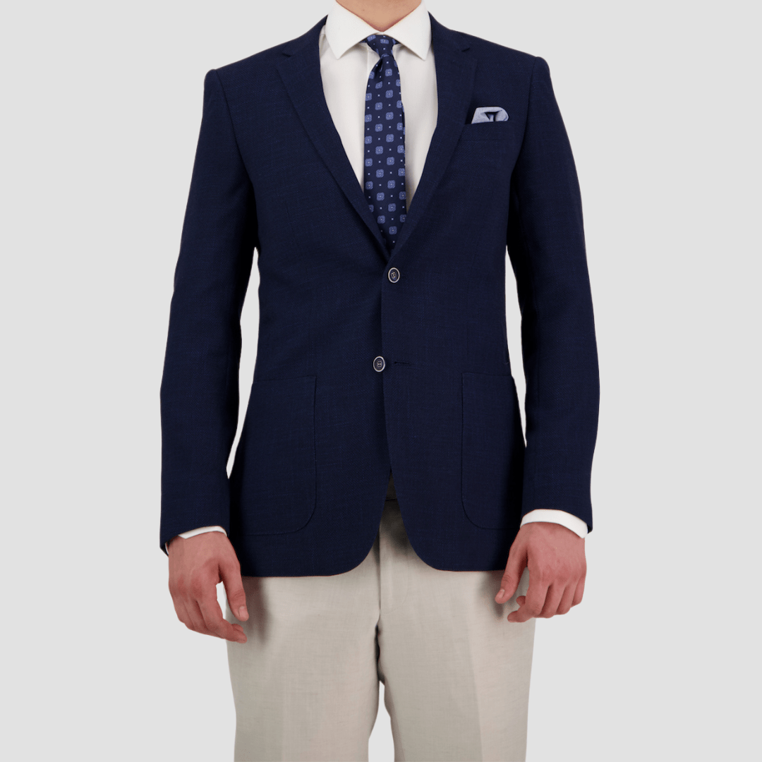 A tailored fit navy sports jacket with notch lapel, two button front, patch pockets, and four button sleeve by Bruton.