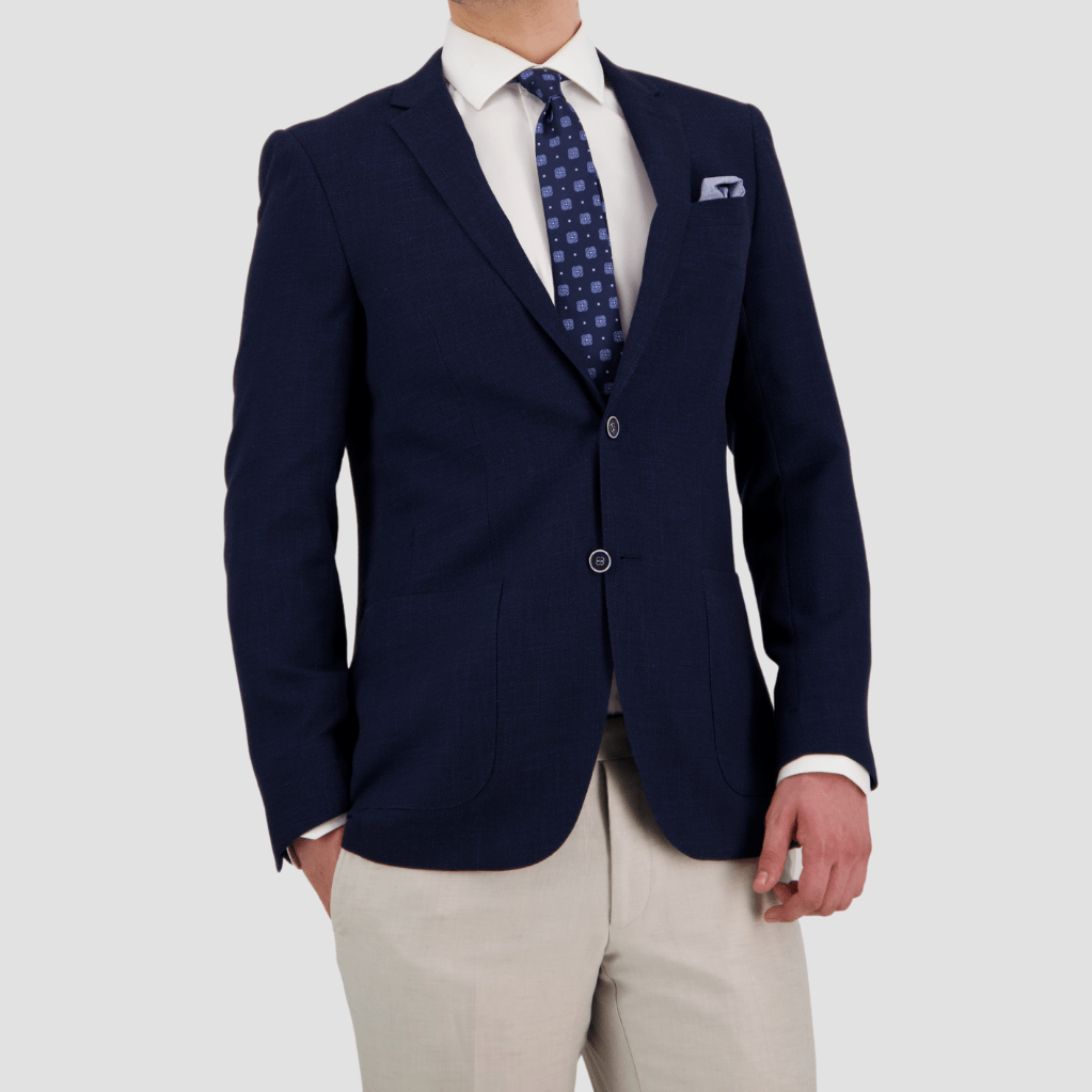 A tailored fit navy sports jacket with notch lapel, two button front, patch pockets, and four button sleeve by Bruton.