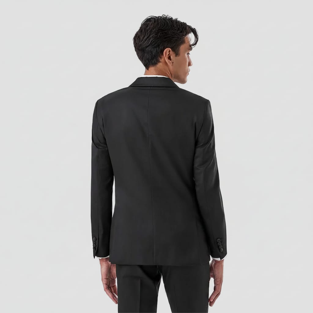 A man shown from the back wearing a black suit jacket and matching trousers against a plain white background.