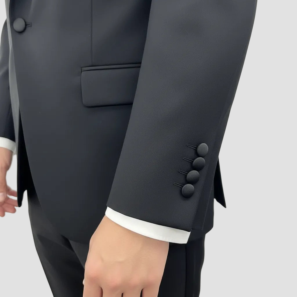 Close-up of a dark gray suit with buttons on a plain background