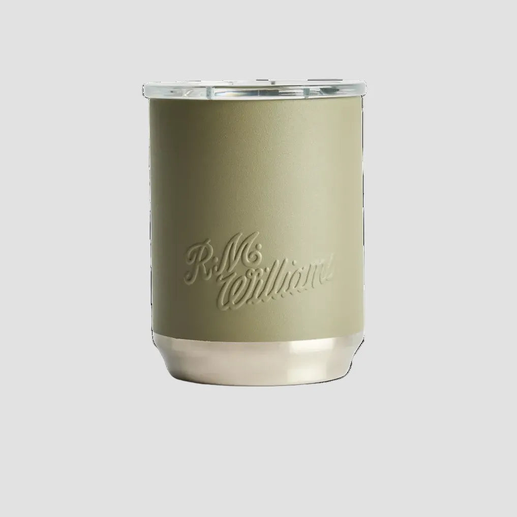 A matte sage green insulated tumbler with a silver metal base and lid, featuring the embossed brand name 'R.M.