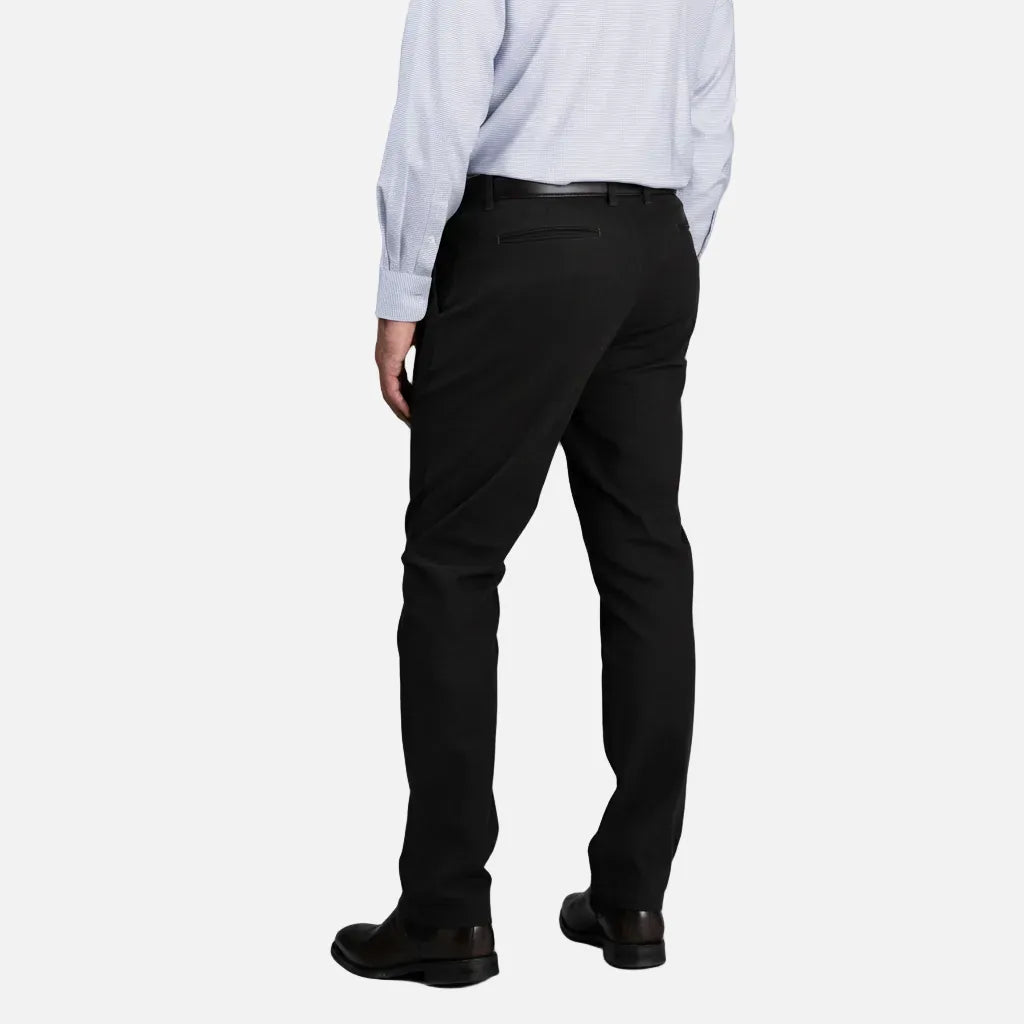 Person wearing black dress pants with a light blue shirt on a gray background
