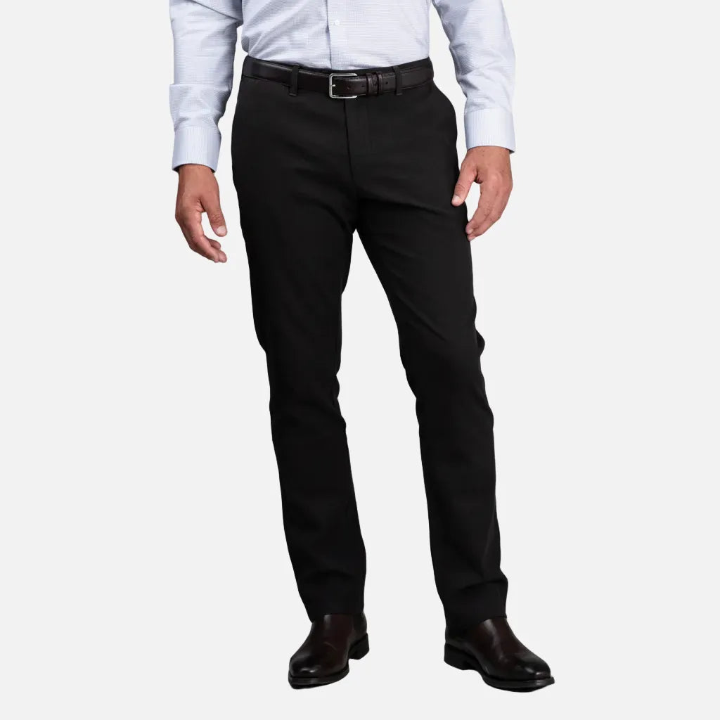 Person wearing black dress pants with a plain background