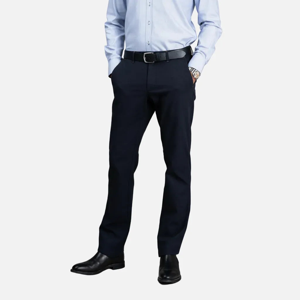 Person wearing a light blue dress shirt, dark navy pants, and black shoes on a gray background