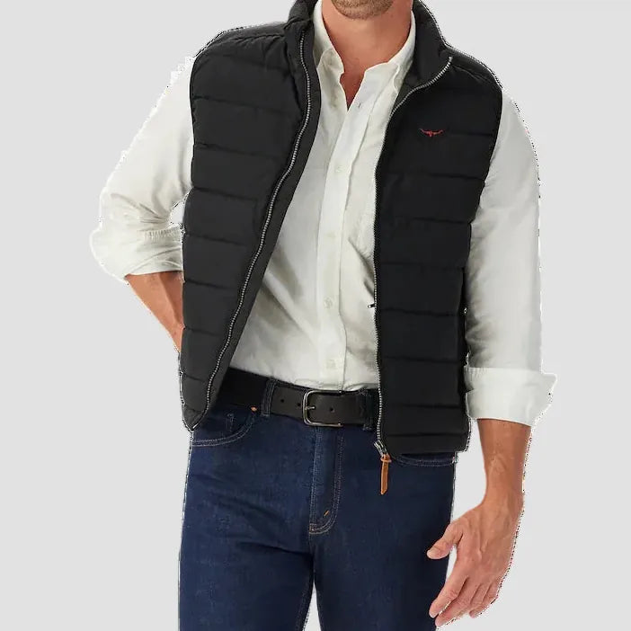 Man wearing a black puffer vest over a white shirt with a white background