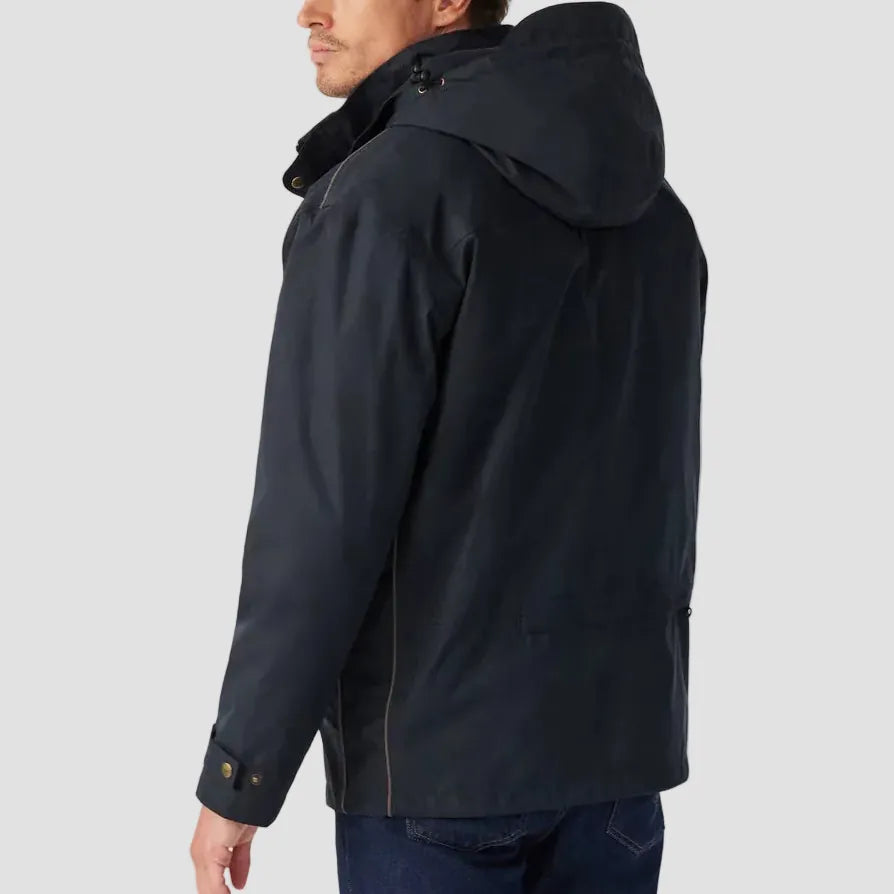 Man wearing a black jacket with a hood on a light gray background