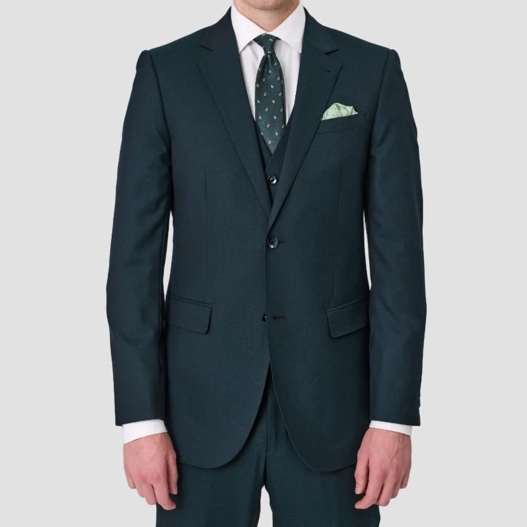 Forest green suit by Savile Row, single breasted, notched lapel and flap pocket, with a white shirt, green tie, and pocket square.
