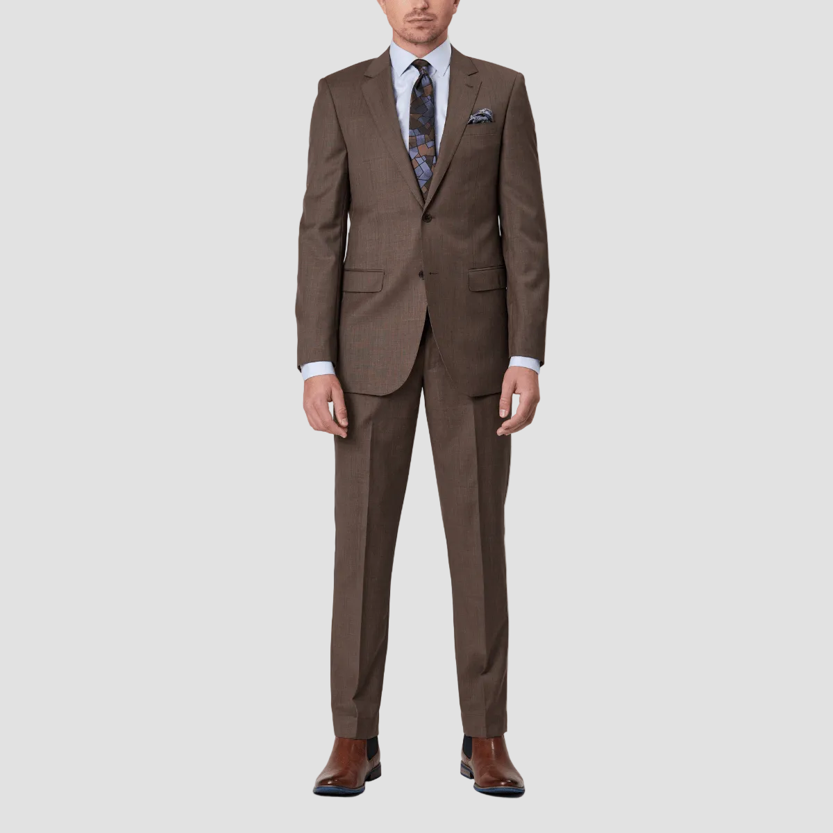 A latte brown wool suit with a tailored fit, by Savile Row, including a jacket and trousers, paired with brown leather shoes.