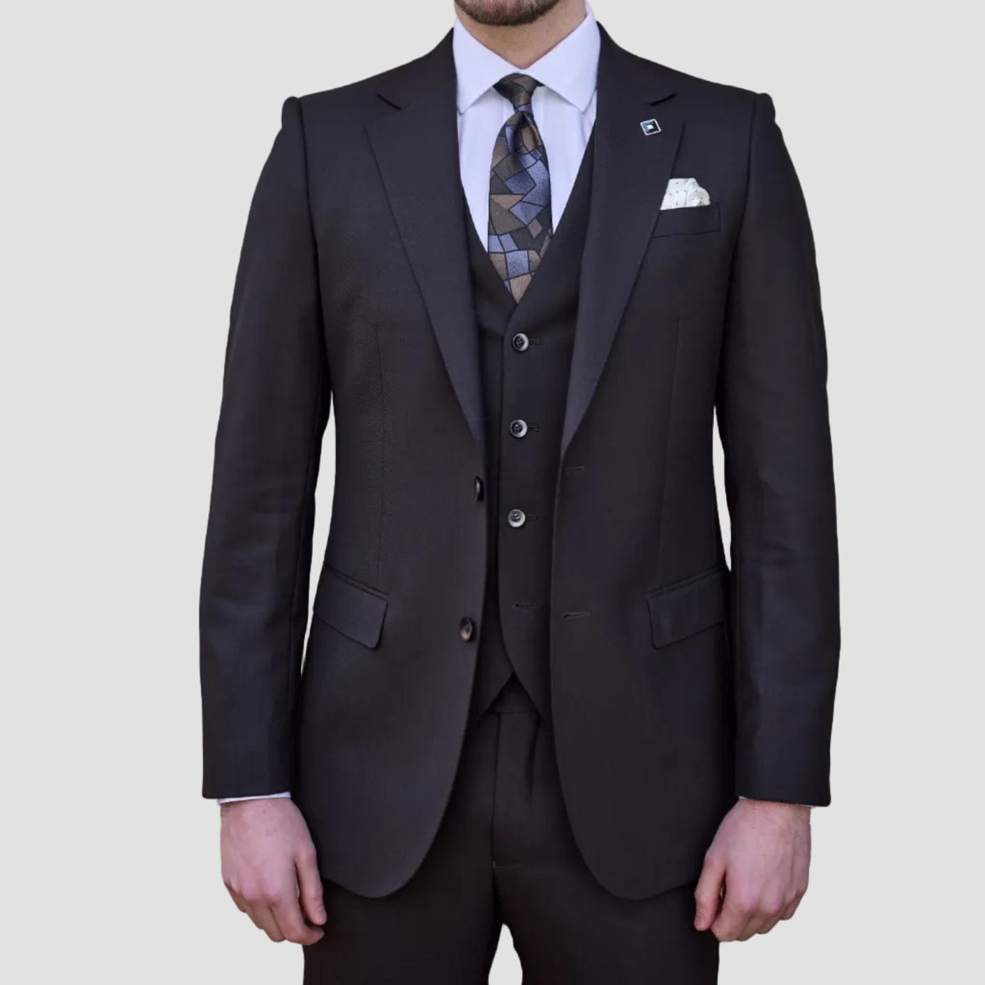 Black-brown single breasted merino wool suit by Savile Row paired with matching trousers and patterned tie.