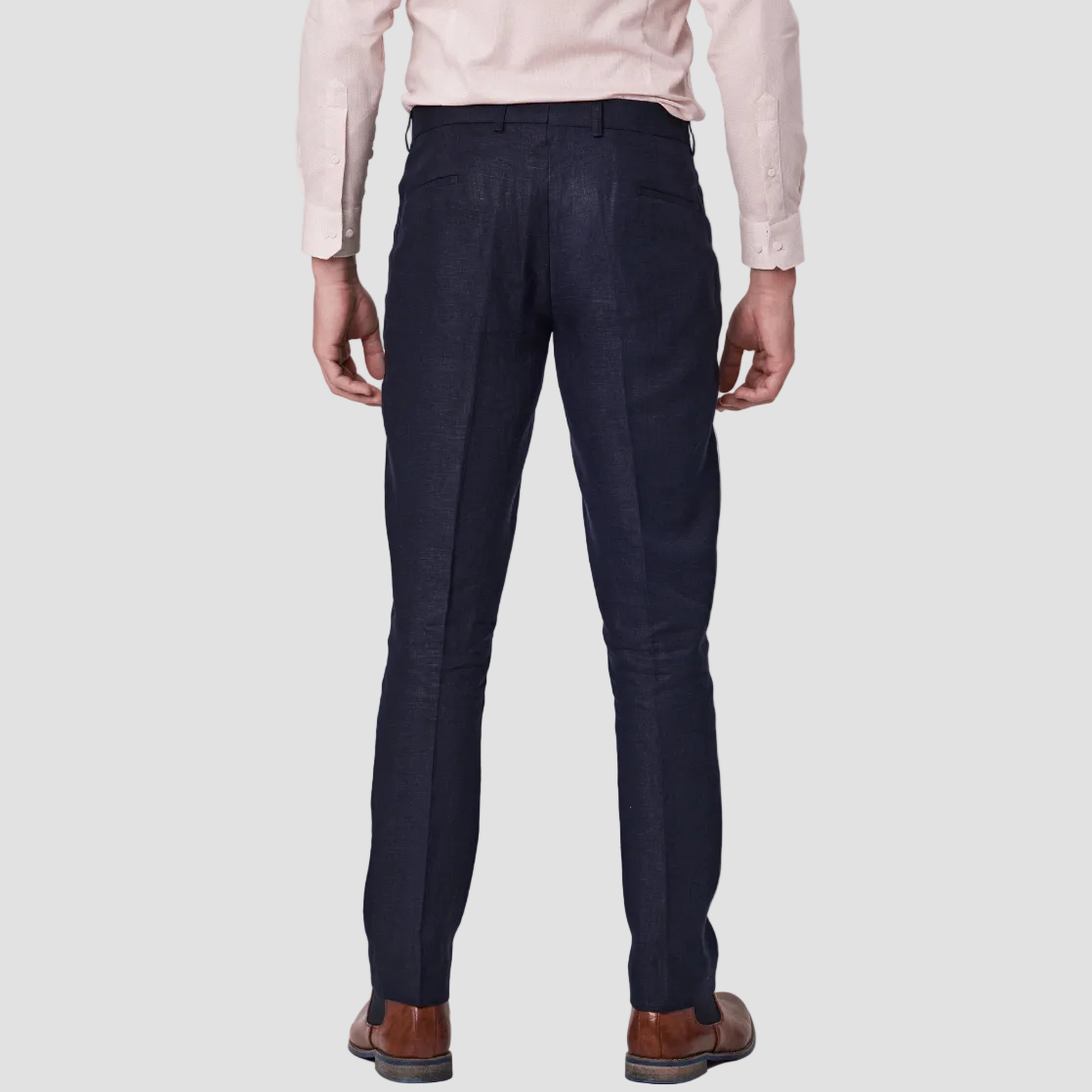 Navy linen tailored fit trousers and a pink dress shirt, paired with brown leather shoes.