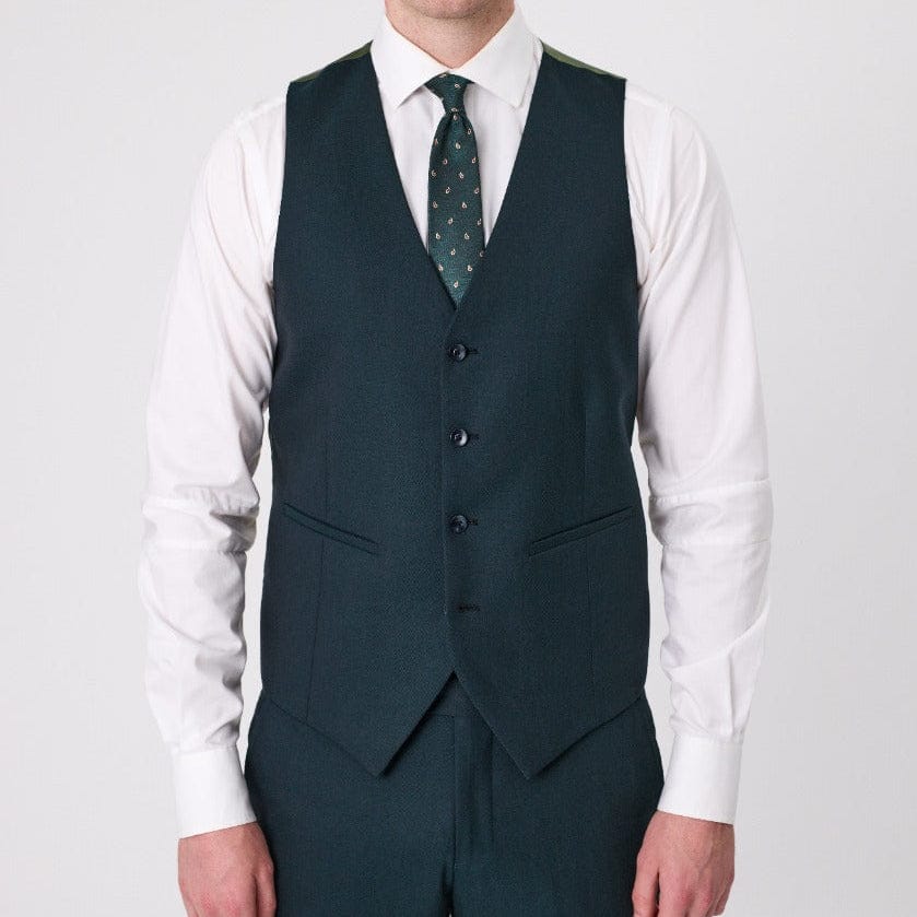Man wearing a forest green merino wool vest by Savile Row over a white shirt with a patterned tie.