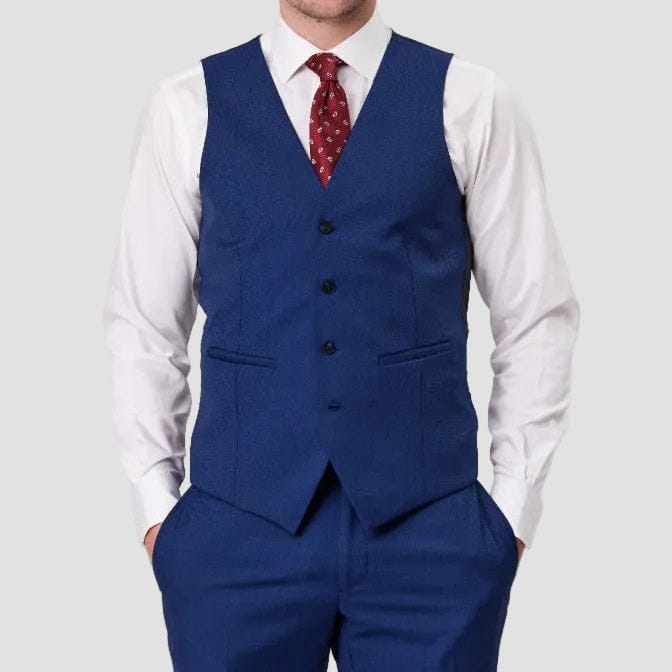 Man wearing a denim-blue suit vest by Savile Row with a white shirt and red tie.