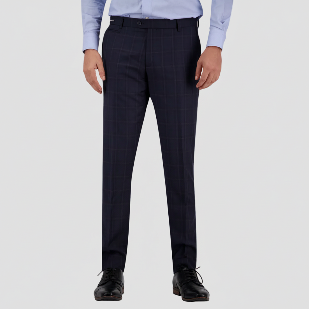 A man standing in a shirt and tie, wearing midnight blue tailored fit suit trousers.