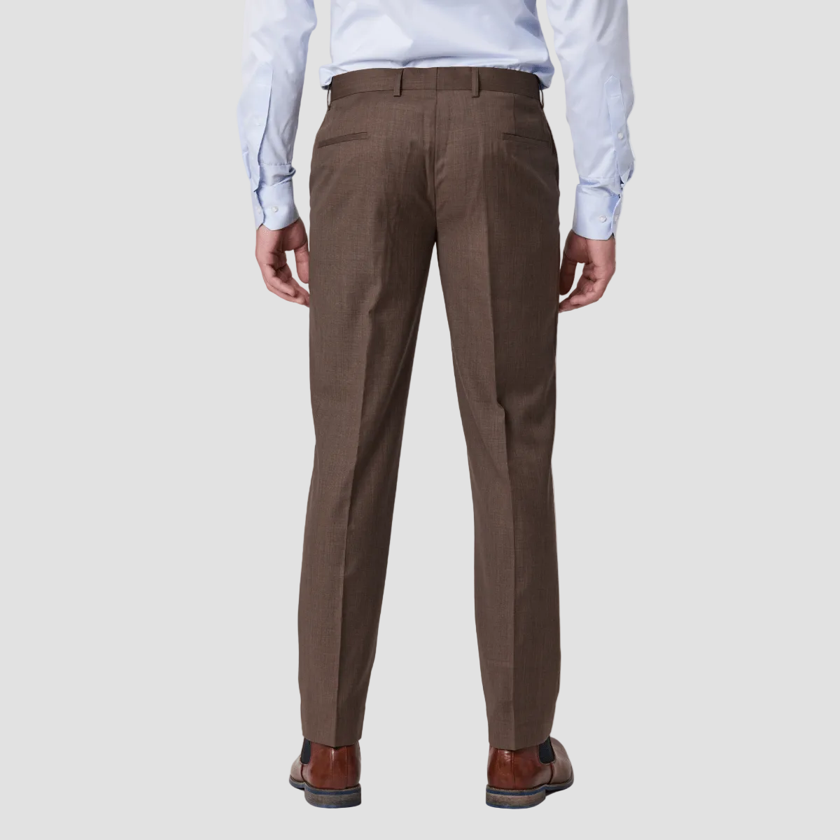 A man wearing a brown pure merino wool suit trouser by Savile Row with brown leather boots.