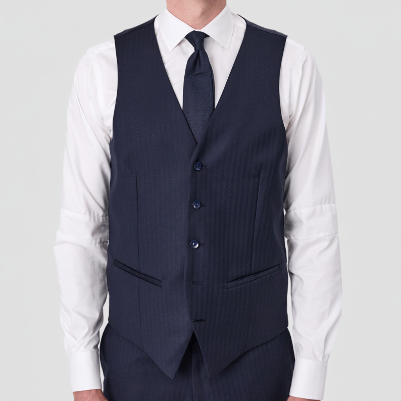 Navy blue Tasmanian wool vest with Satin back and adjustable tab by Savile Row worn over a white shirt with matching pants and a dark blue tie.