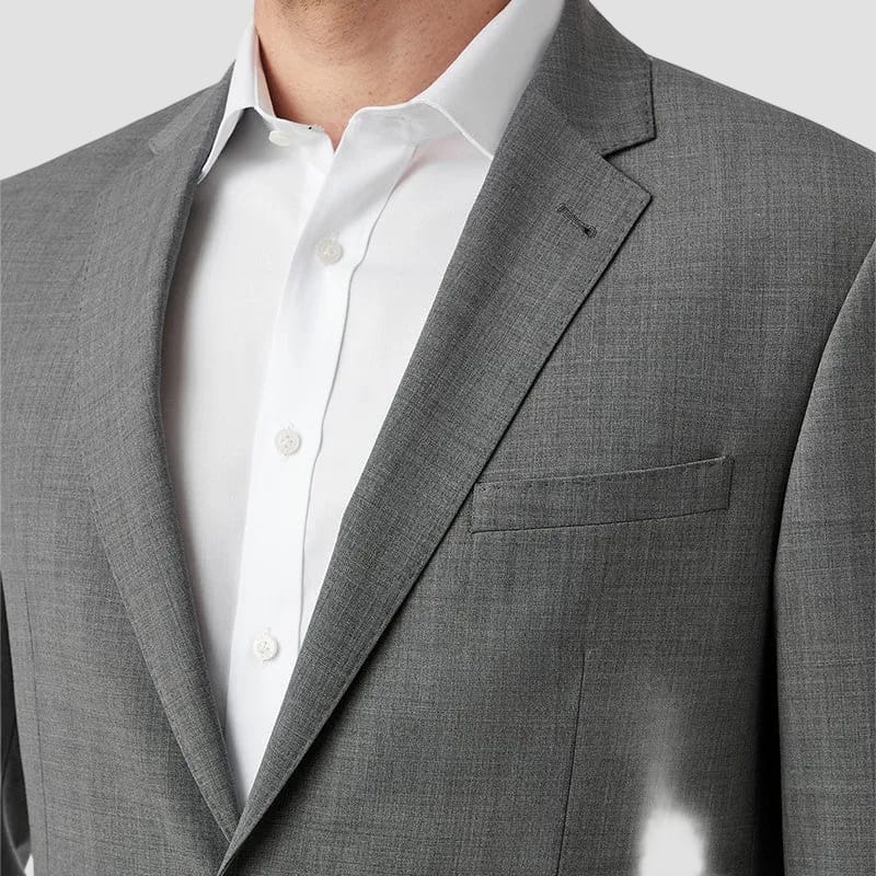 Gray suit jacket over a white shirt on a plain background