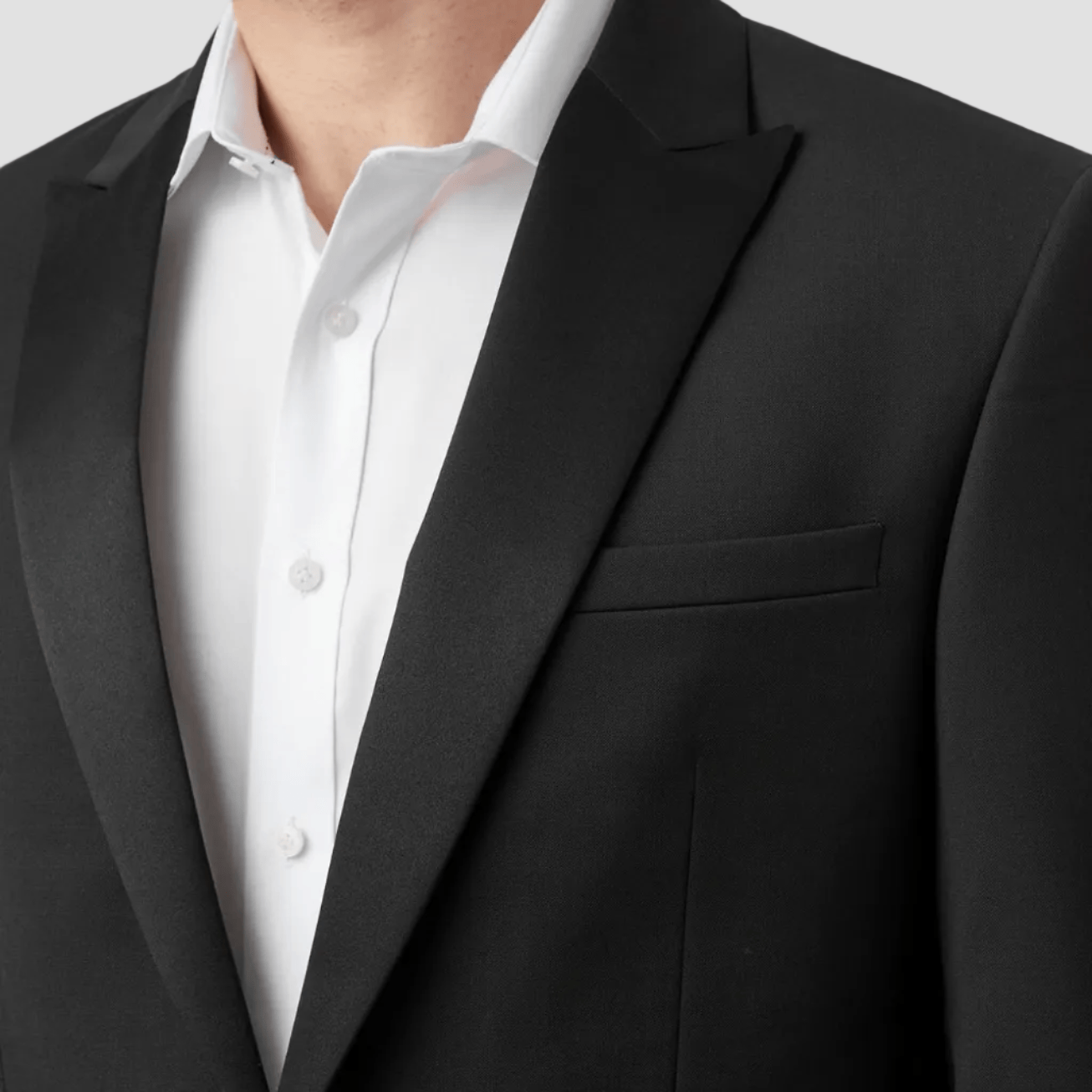 Black suit jacket over a white shirt on a plain background