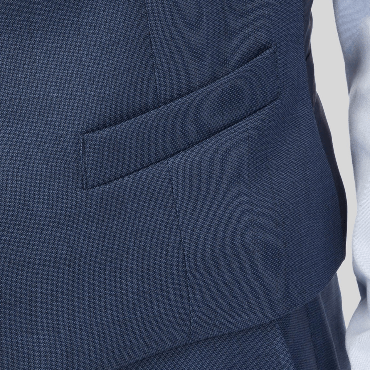 A close up of the mighty vest in blue with front welt pockets