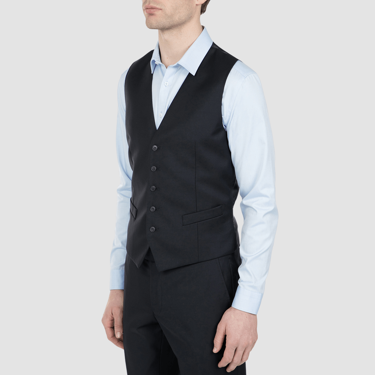 a navy blue mens vest over a light blue business shirt