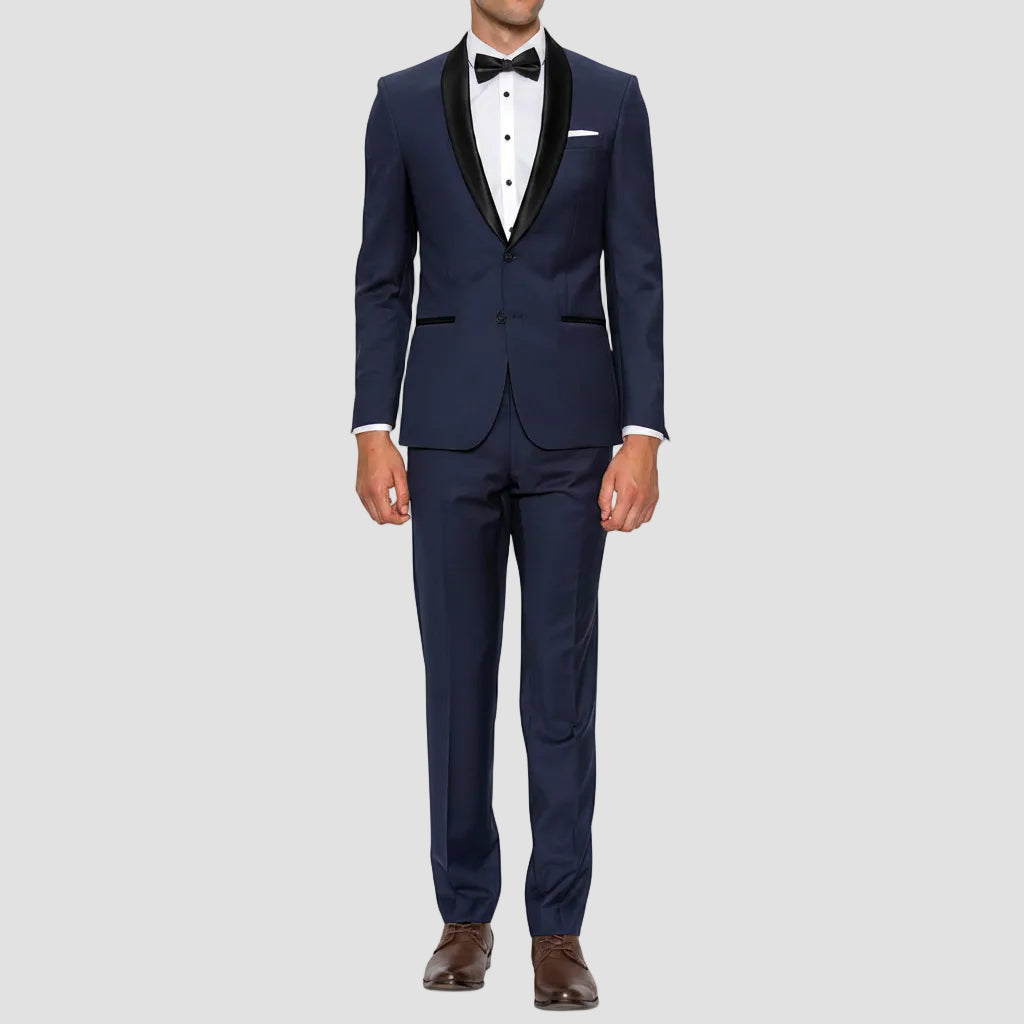 Gibson’s Spectre navy tuxedo blends a satin shawl lapel, jet pockets and 2‑button front with slim trousers.
