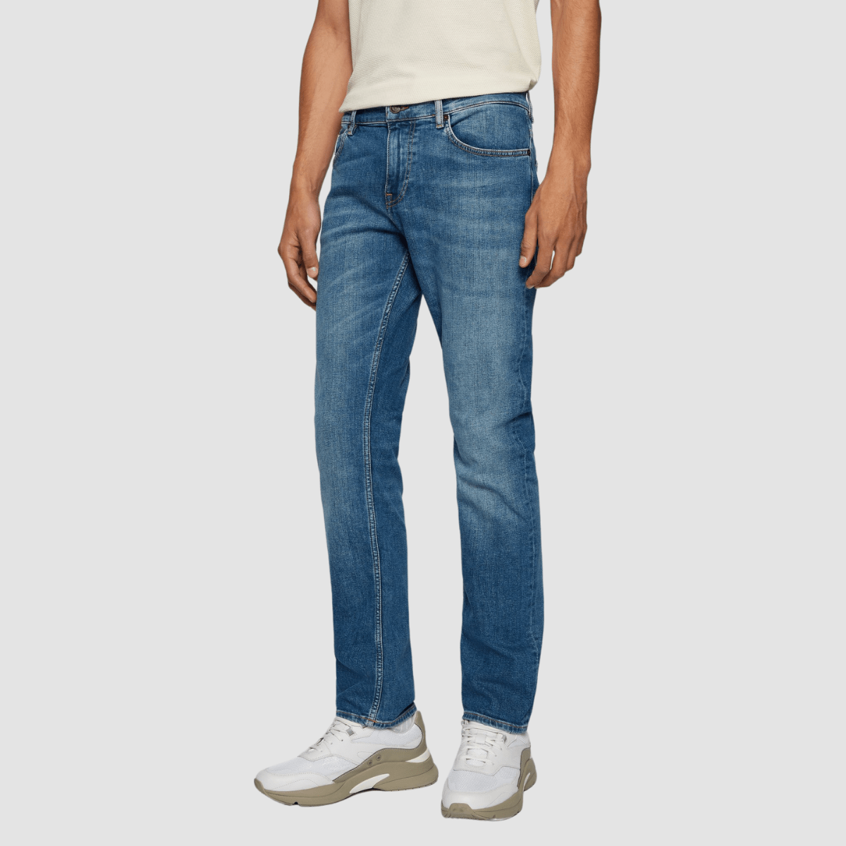 hugo boss denim worn with sneakers and a white t-shirt the denim is washed out the leg is a straight tapered look