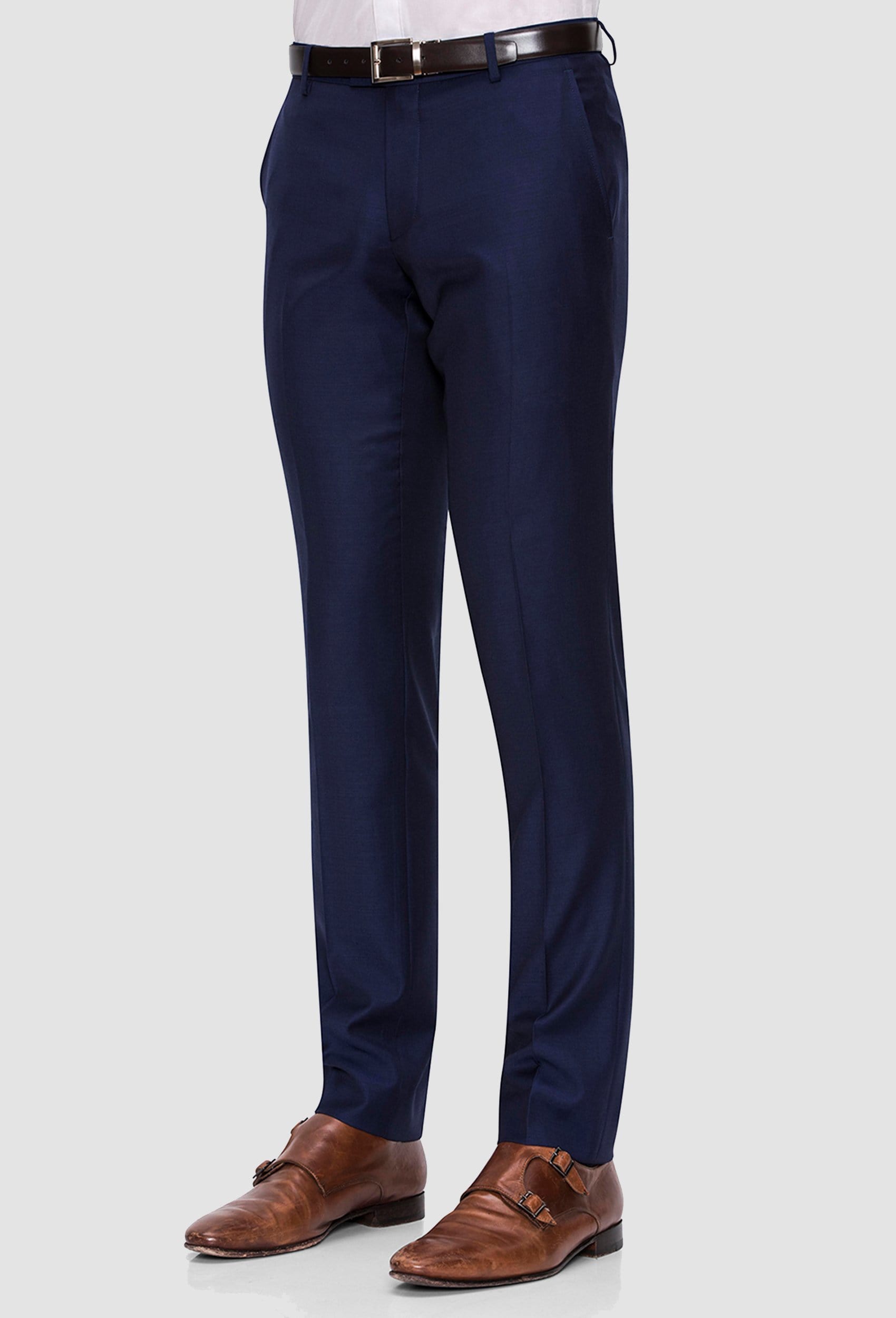 a side on view of the Joe Black slim fit razor trouser in navy pure wool styled with tan accessories