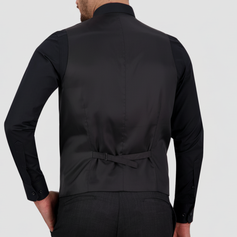 Man wearing a charcoal satin backed vest, with an adjustable tab, and matching pants by Savile Row and a black shirt.
