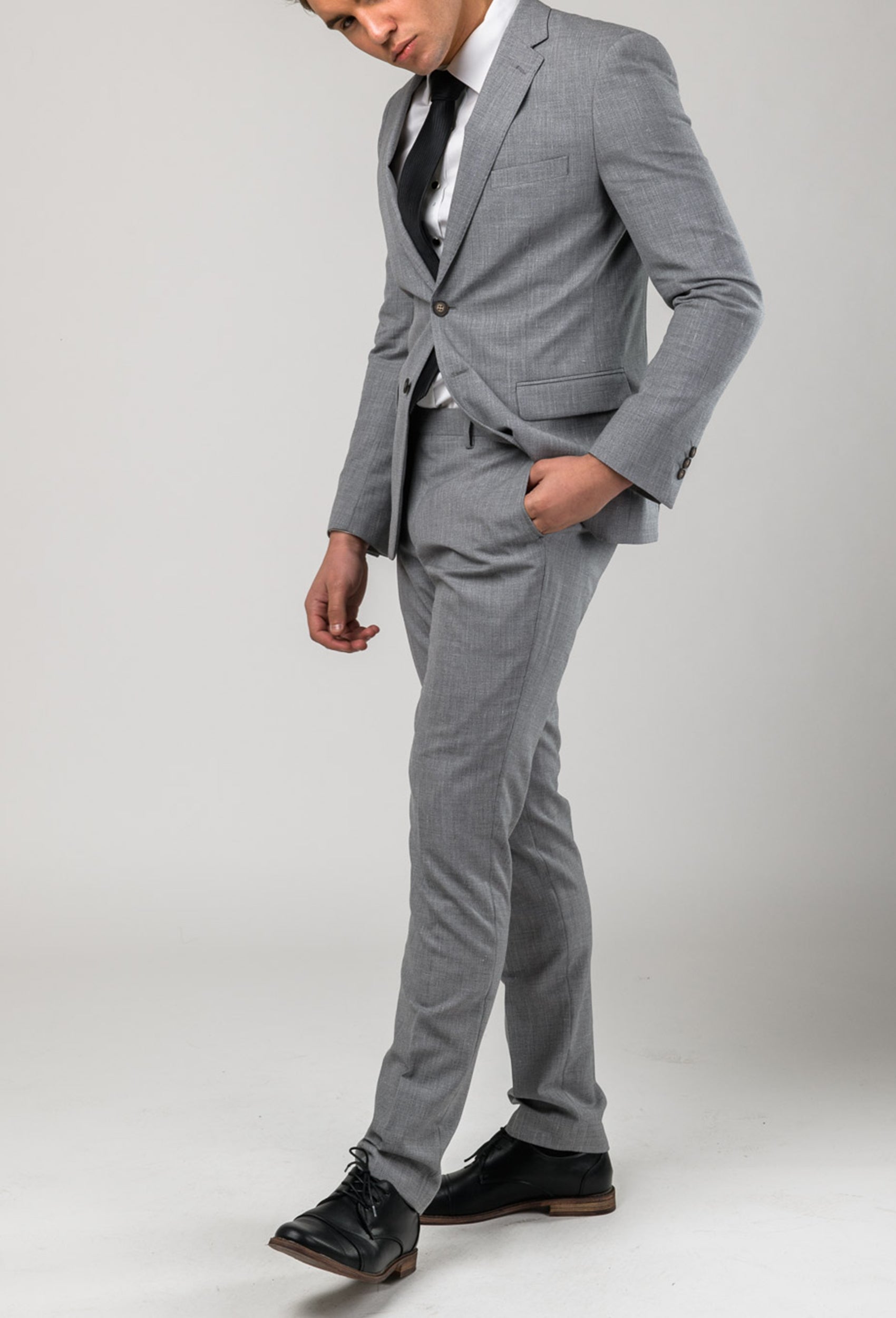 a man wears a light grey suit with a white shirt and a black tie