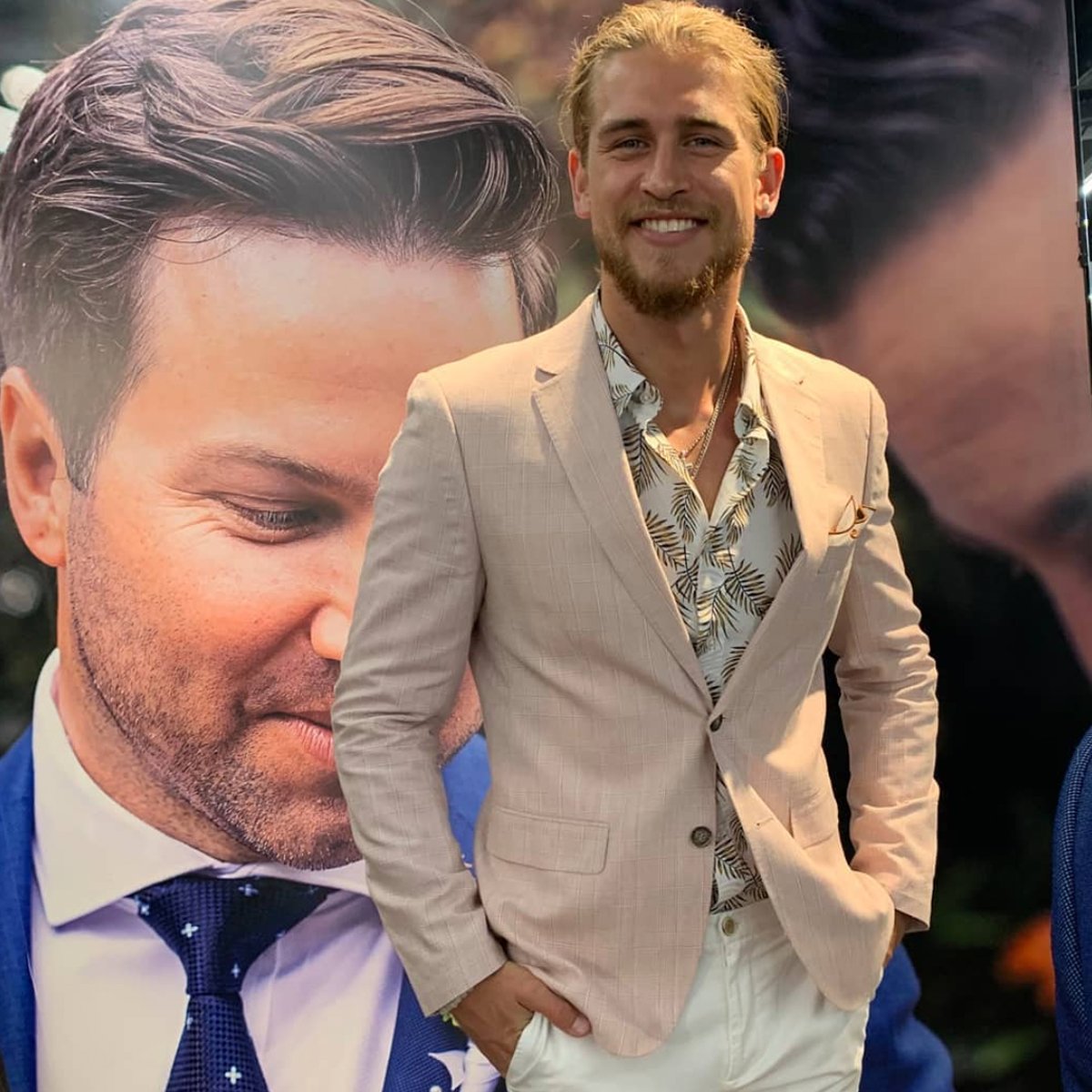 a man in mens suit warehouse store wears a printed linen casual shirt with a beige blazer over the top