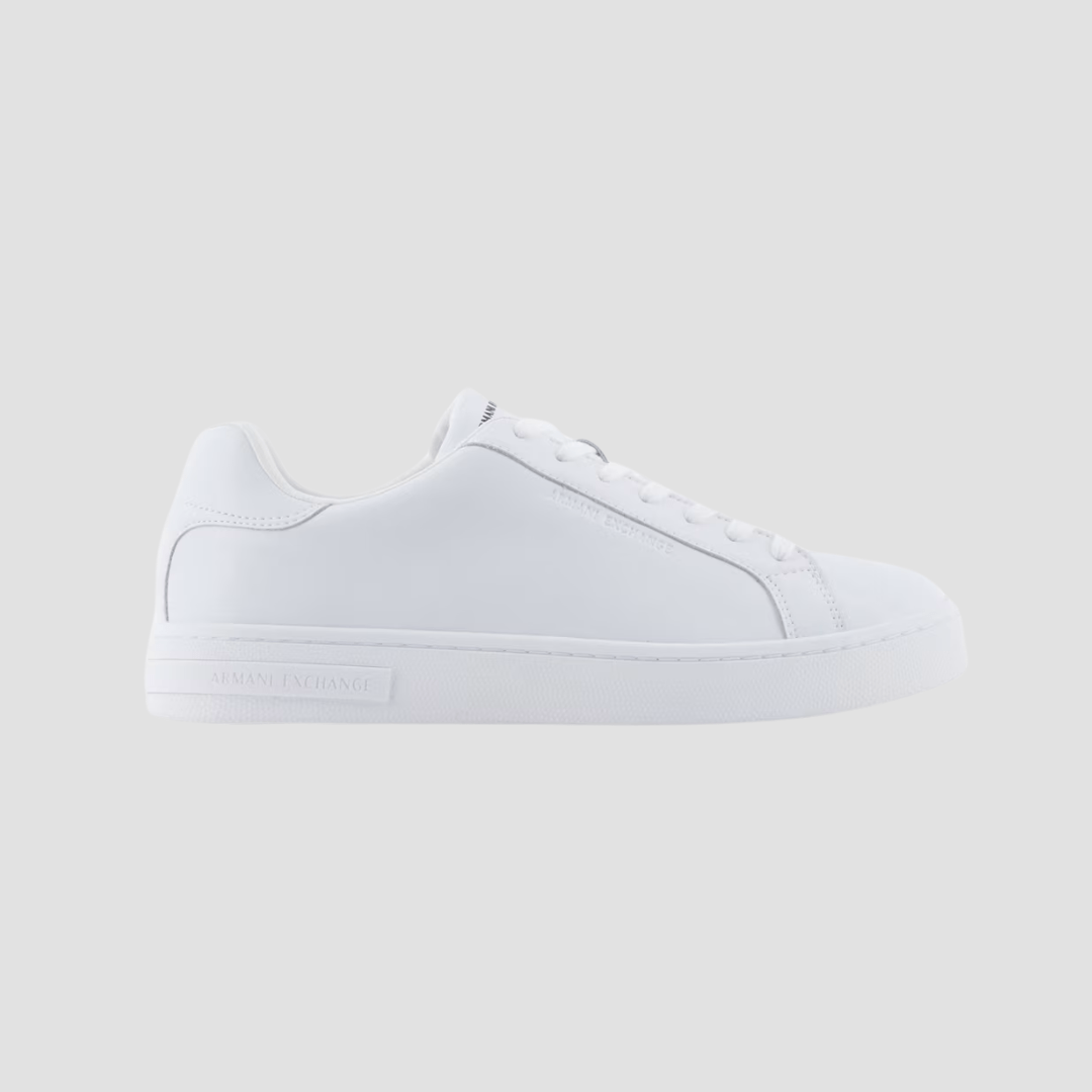 A white leather low-top sneaker with lace-up closure, featuring the Armani Exchange logo on the side, tongue, and heel.