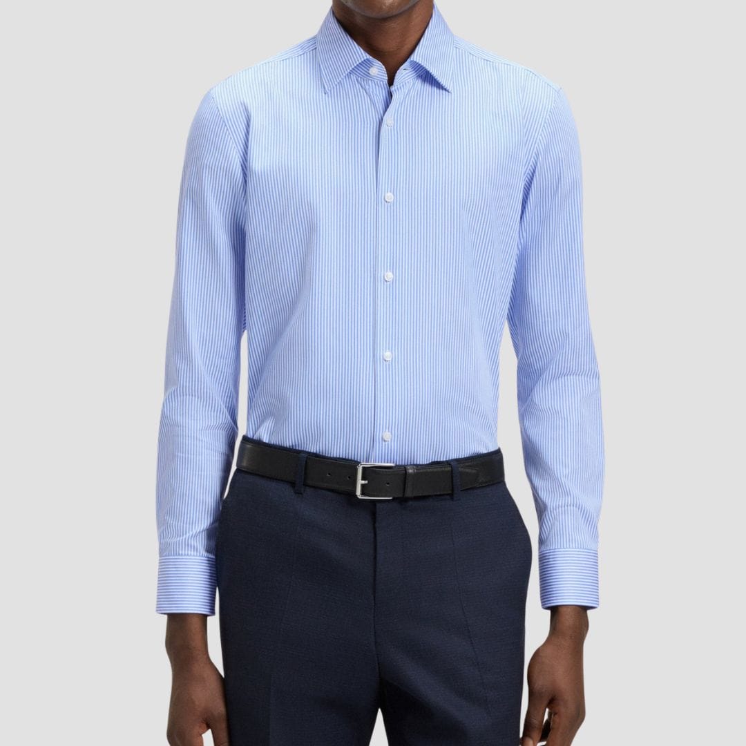 Man wearing a light blue striped dress shirt and dark pants 