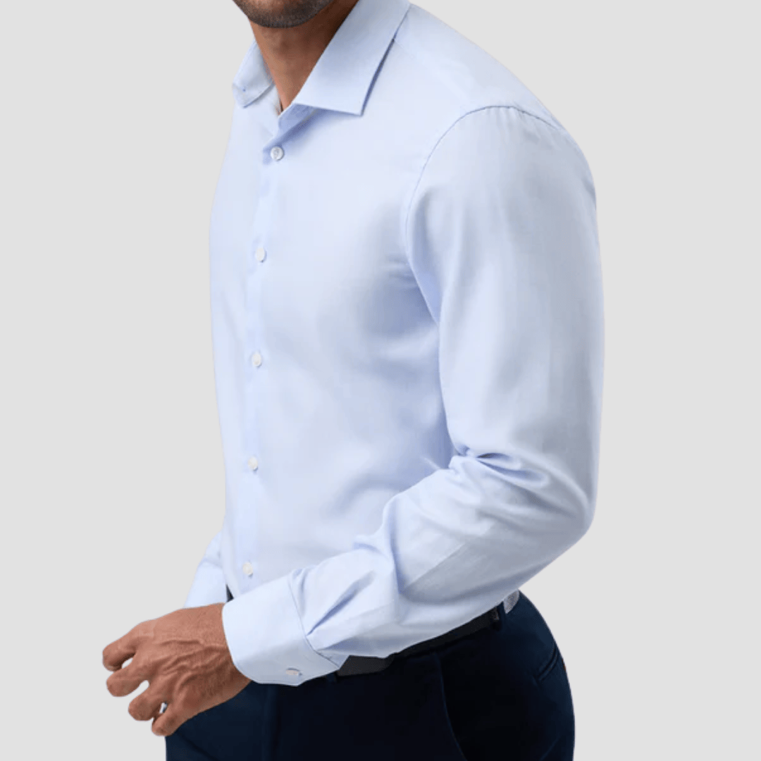 Man wearing a light blue dress shirt with rolled-up sleeves 