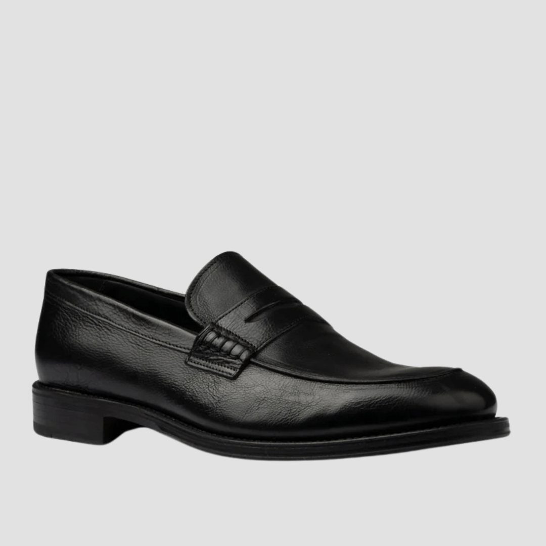 Black leather loafer shoe on a light gray background