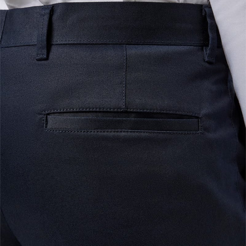 Close-up of the back waistband and pocket area of dark navy chinos, worn with a white shirt.