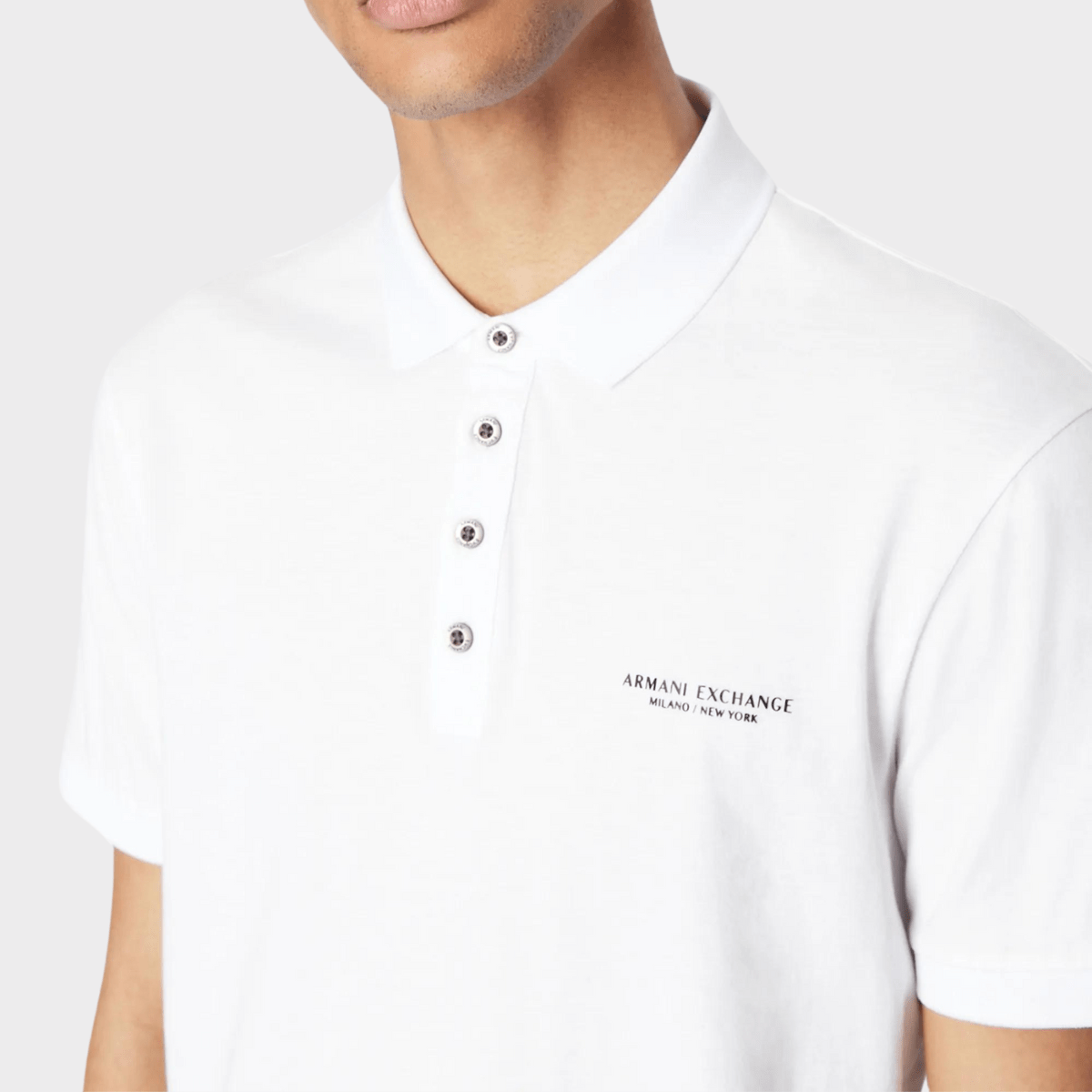 Button and collar details of men's white polo shirt by Armani