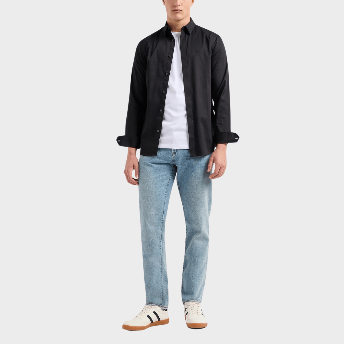 The slim-fit cotton stretch shirt in black paired with jeans and white shirt.
