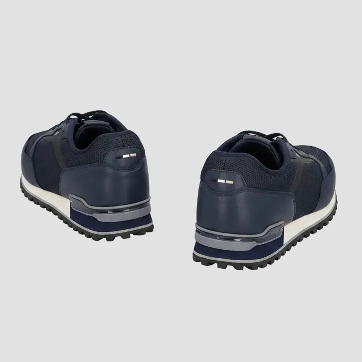 A pair of navy blue low-top sneakers shown from the rear three-quarter view, featuring a textured sole with a white midlayer and dark outsole.