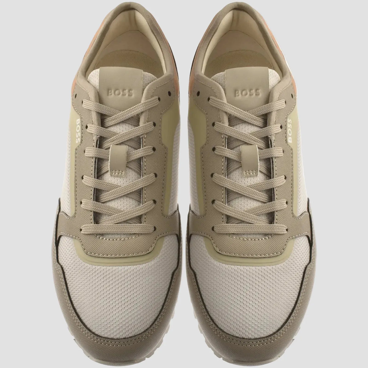 A pair of BOSS low-top sneakers shown from a top-down view. The shoes feature a color-blocked design in beige, cream, and taupe tones with matching beige laces, set against a plain white background.