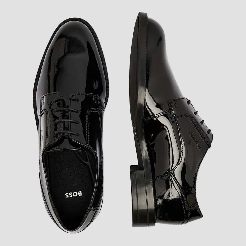 A pair of glossy black patent leather oxford dress shoes, shown from the top and side angles on a plain white background. The brand name 'BOSS' is visible on the insole of the left shoe.
