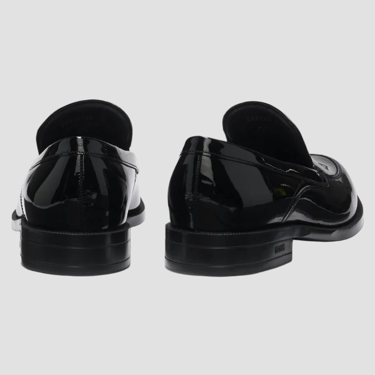 Black patent leather loafers on a white background