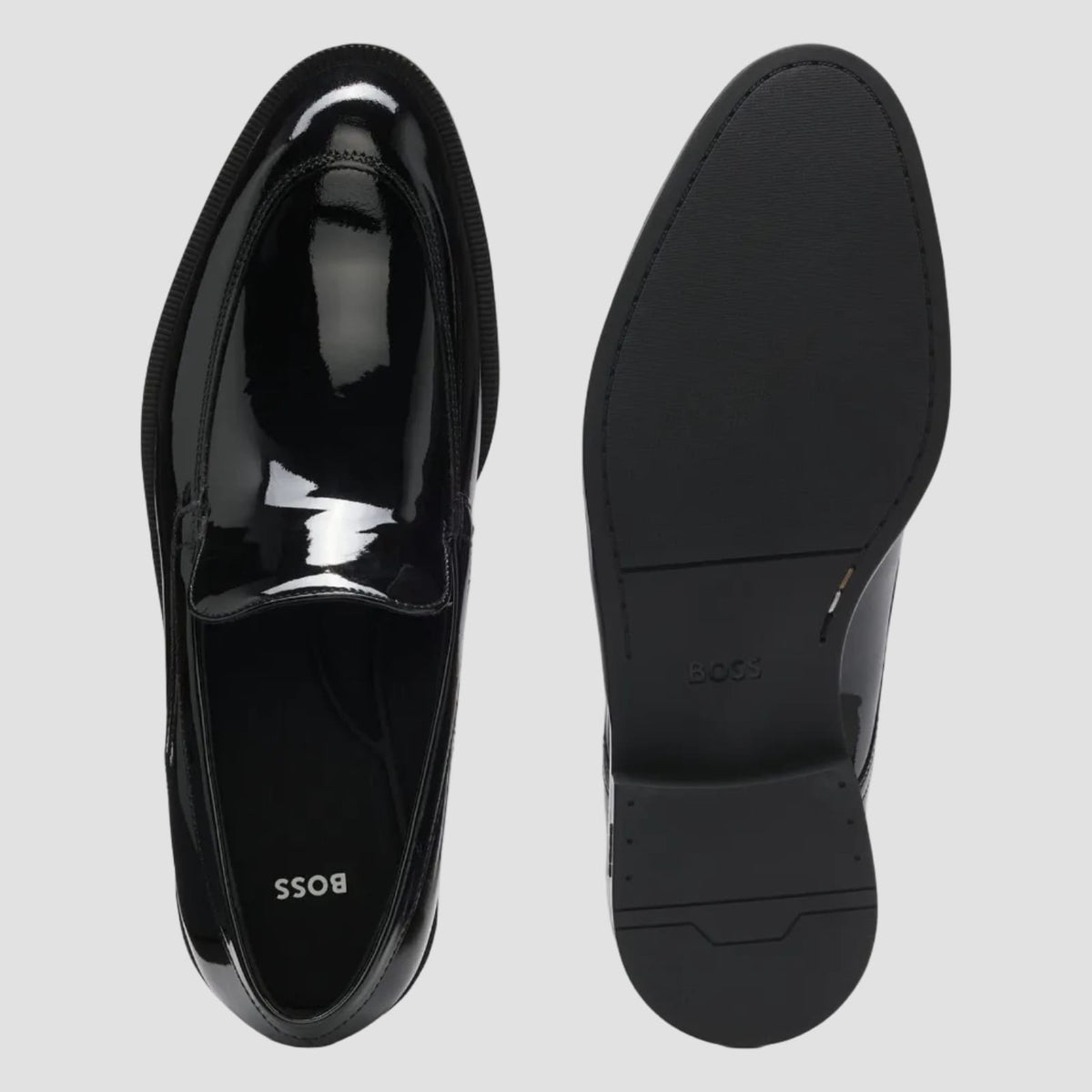 A pair of black patent leather loafers shown from the top and side, with the brand name BOSS visible on the insole, against a light gray background.